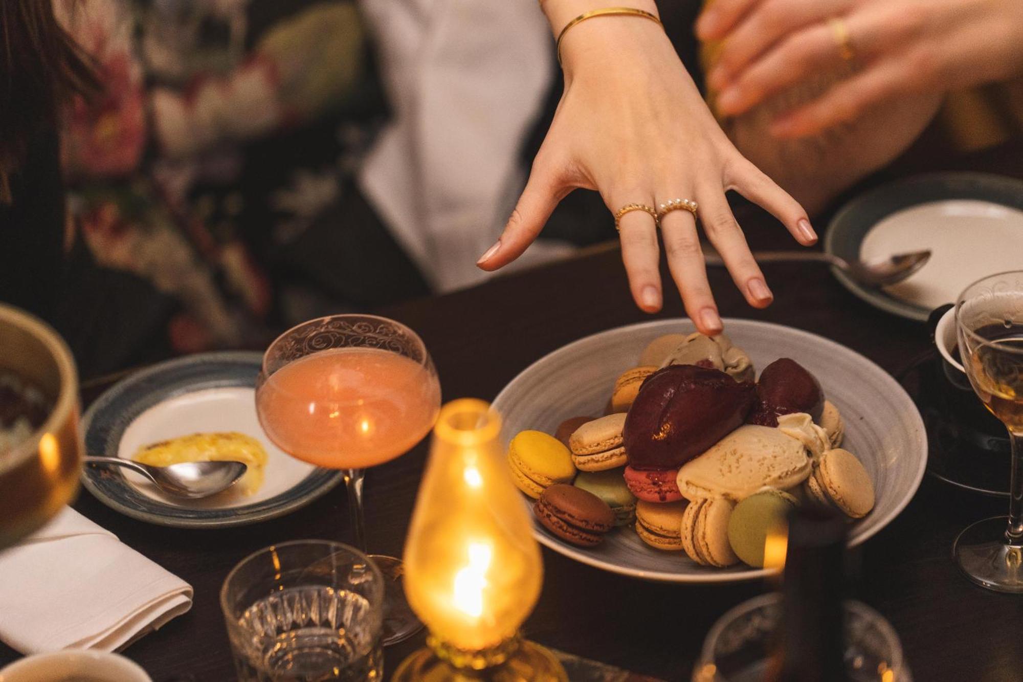 Hotel Pigalle Göteborg Dış mekan fotoğraf A woman's hand reaches for a plate of macarons